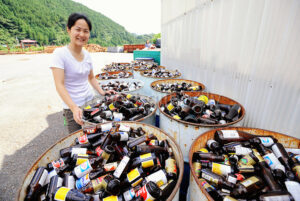 Sonae Fujii of the Zero Waste Academy in Kamikatsu stands next to containers filled with waste