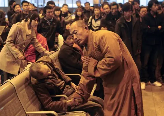 A Buddhist Monk was captured by a photographer that was in a crowd at a train station, blessing a dead man.
